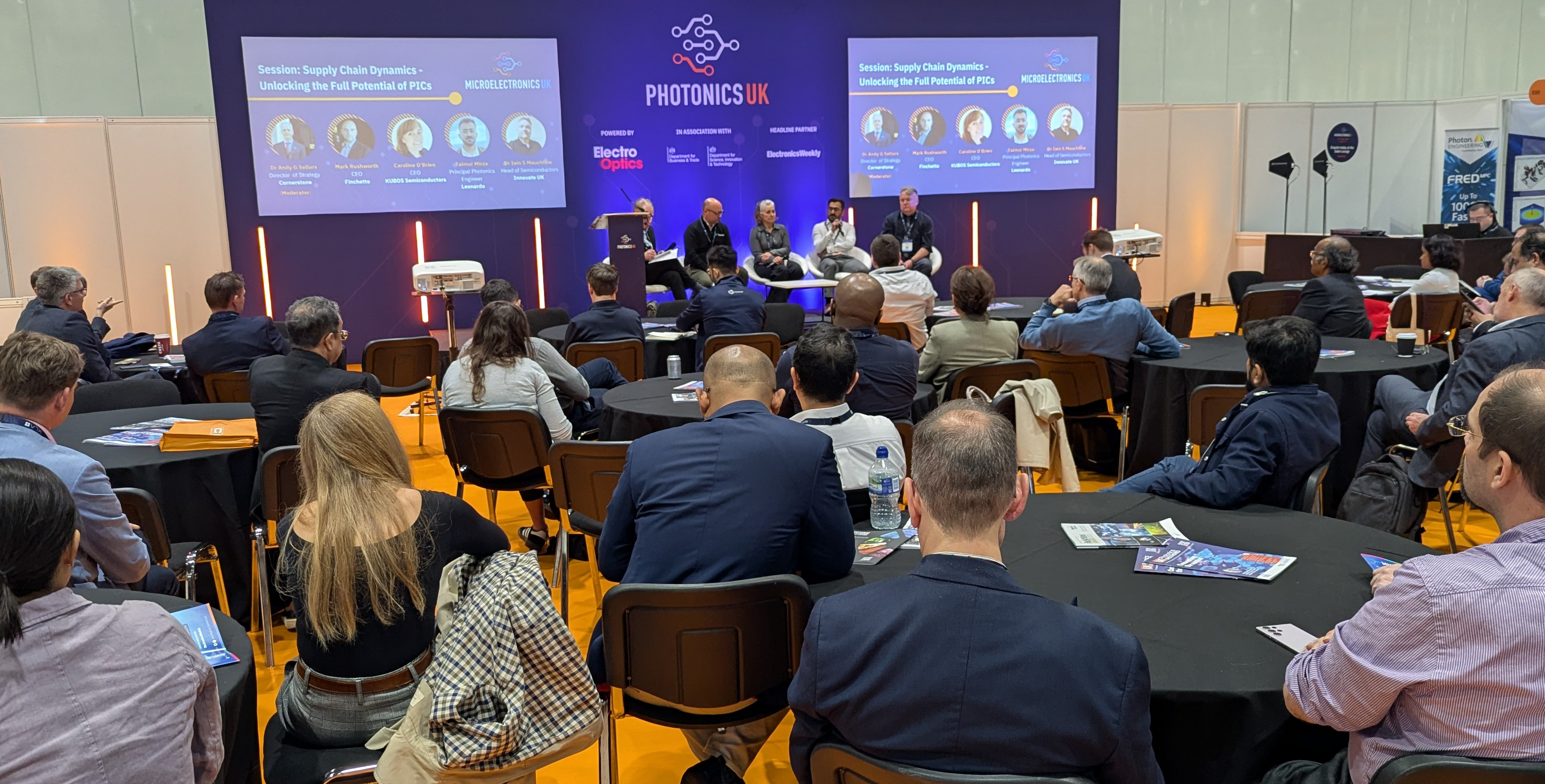 A crowd of people sitting before a stage at Photonics UK