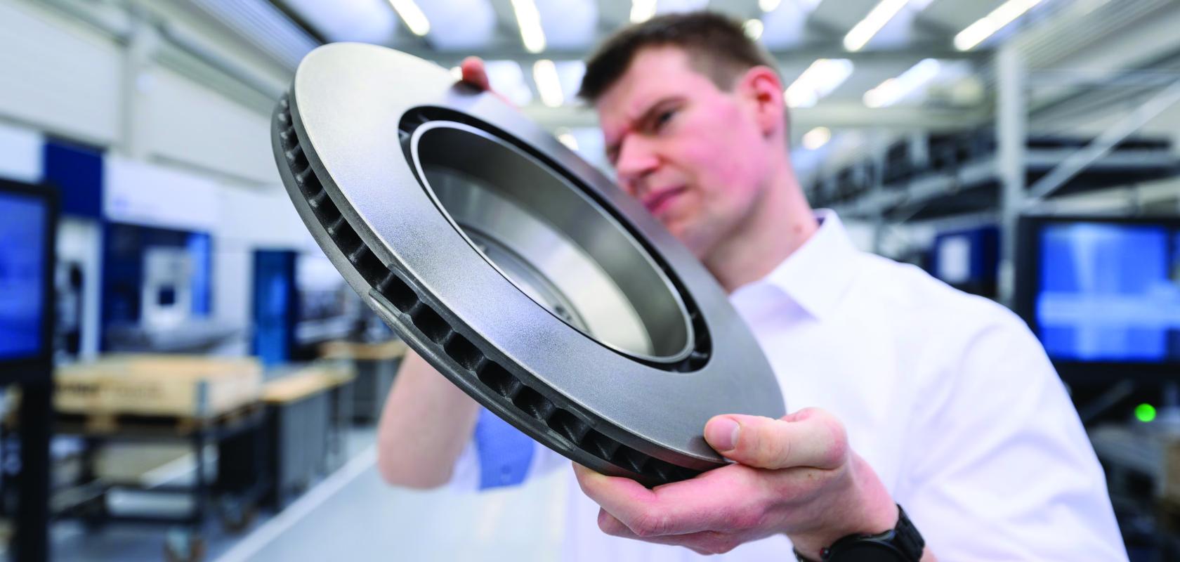 A TRUMPF employee with a brake disc